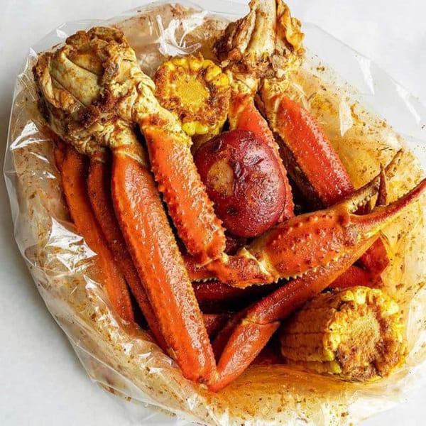 Miso Seafood's crab legs, corn on the cob, and potatoes in a clear plastic bag.