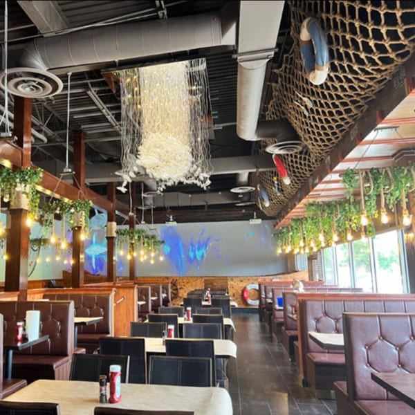 MISO SEAFOOD restaurant interior with nautical decor, brown booths, and hanging lights.