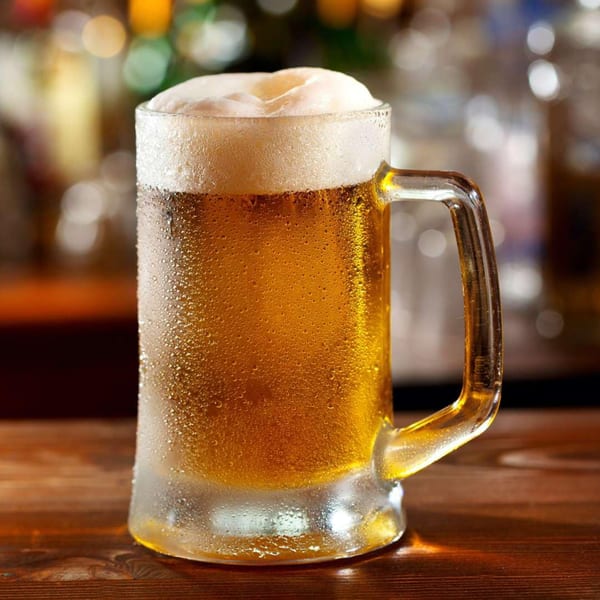 A frosty mug of MISO SEAFOOD beer with a foamy head sits on a wooden bar.