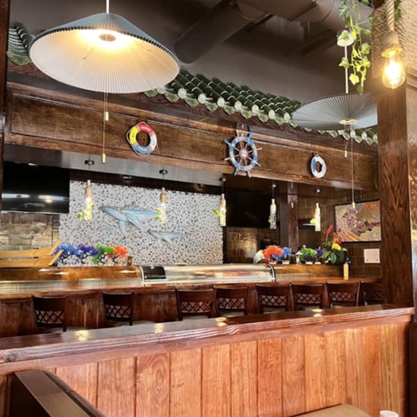MISO SEAFOOD's sushi bar with wooden chairs, nautical decor, and hanging lights.